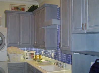 laundry room with blue tiled back splash and white cabinets