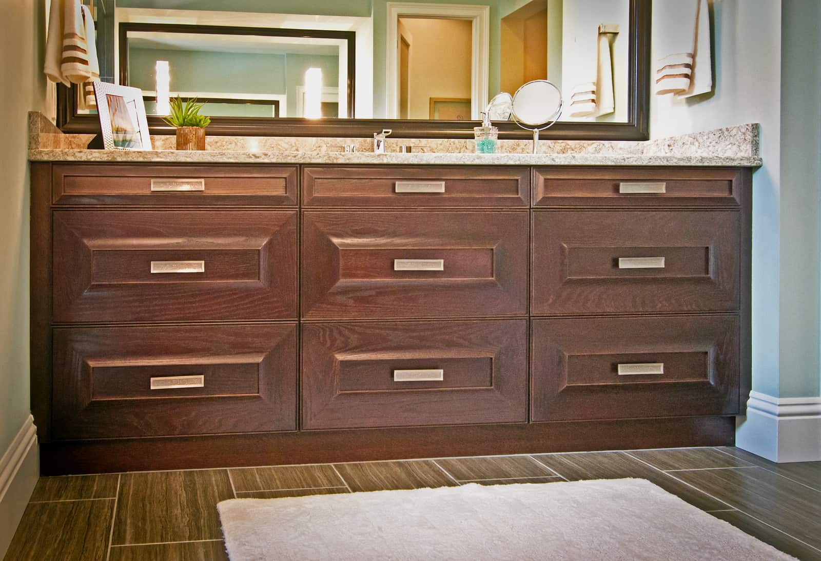 marble topped vanity with dark wood cabinets
